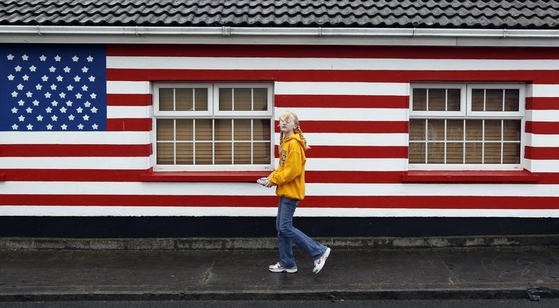 © Reuters. A pedestrian walks past a house painted in the colours of the U.S. flag in Moneygall