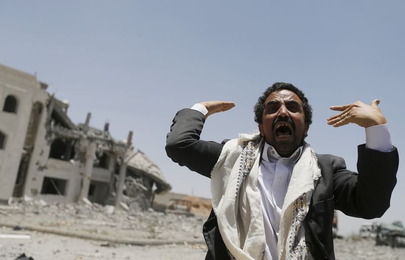 © Reuters. Houthi militant reacts at the yard of residence of the military commander of the Houthi militant group Abdullah Yahya al Hakim after an air strike destroyed it, in Sanaa