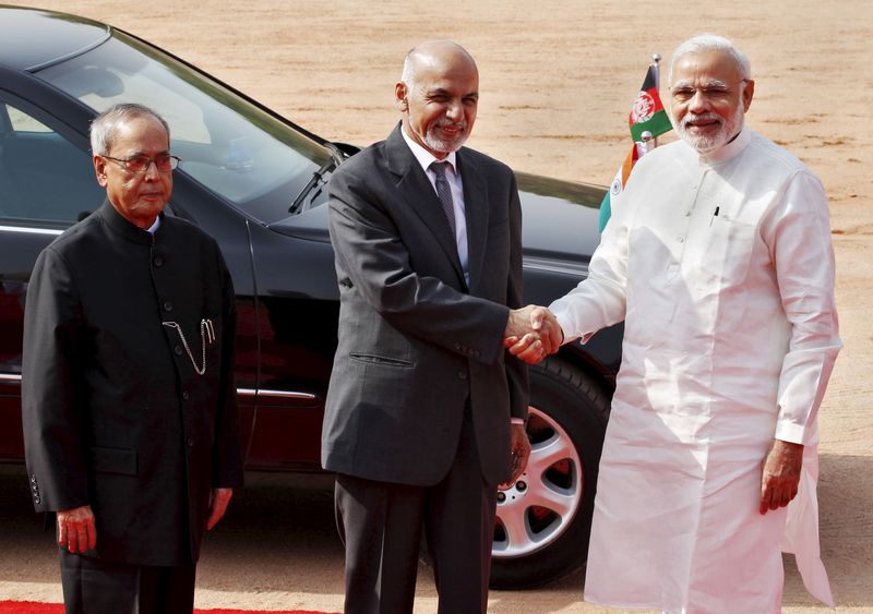 © Reuters. Afghanistan's President Ghani shakes hands with India's PM Modi as his Indian counterpart Mukherjee looks on upon Ghani's arrival to attend a ceremonial reception in New Delhi