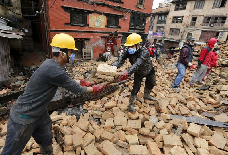 © Reuters. Voluntários ajudam a remover destroços de casa destruída por terremoto em Katmandu