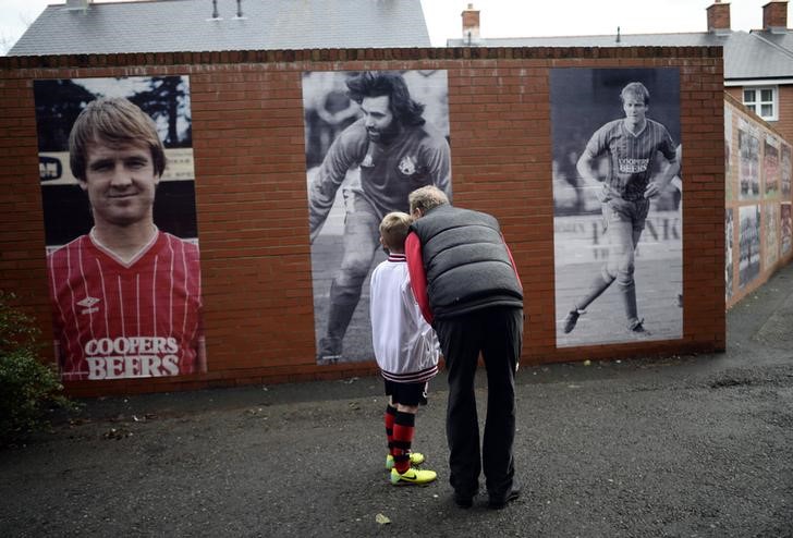 © Reuters. Torcedores observam fotos na parede do estádio Dean Court, do Bournemouth