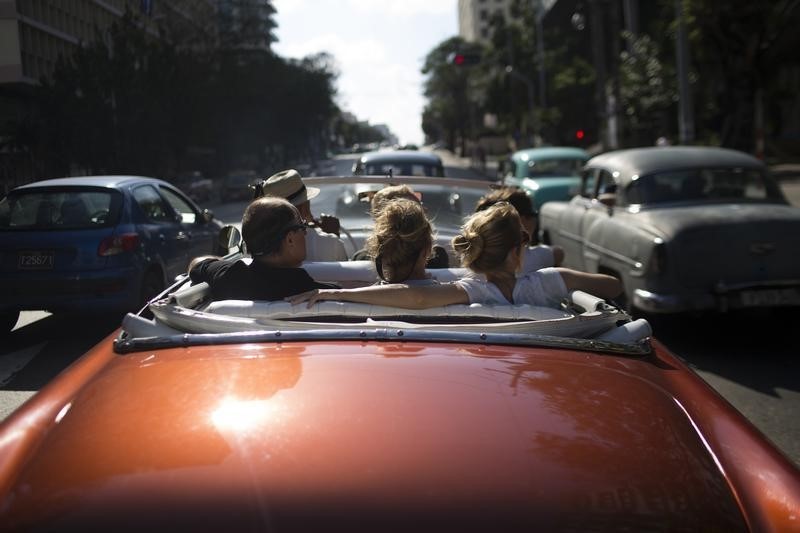 © Reuters. Tourists take a ride in a convertible car in Havana