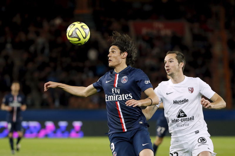 © Reuters. Edinson Cavani, do Paris St Germain, em disputa de volta com Kevin Lejeune, do Metz