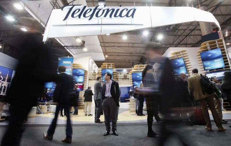 © Reuters. Attendees walk past the Telefonica stand during the Mobile World Congress in Barcelona