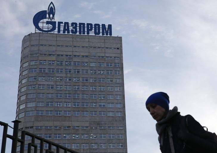 © Reuters. Женщина  проходит мимо штаб-квартиры Газпрома в Москве