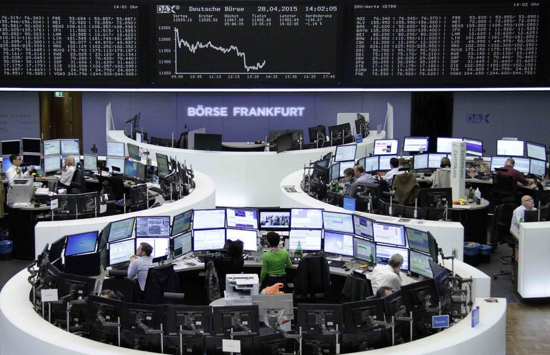 © Reuters. Traders are pictured at their desks in front of the DAX board at the Frankfurt stock exchange