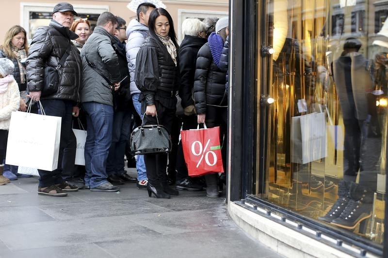 © Reuters. People queue as they wait to enter a shop on the first day of winter sales in central Rome