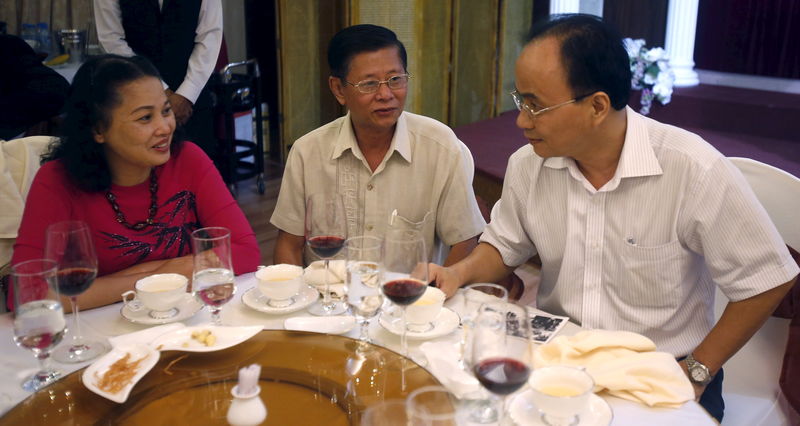 © Reuters. Ho Chi Minh City's Deputy Chairman Le Manh Ha chats with war veteran Nguyen Huy Hoang and Hoang's wife Tong Thi Ngoc Dung during a reception in southern Ho Chi Minh City