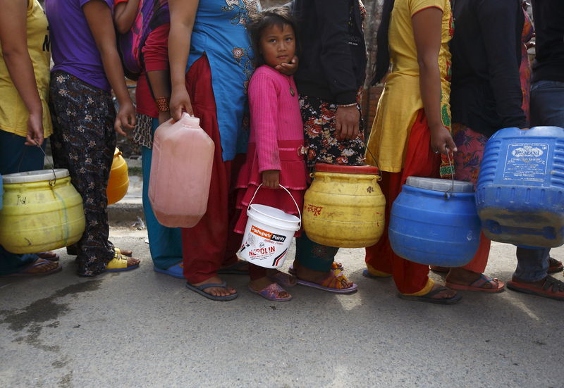 © Reuters. Menina espera em fila para encher recipiente com água perto dos abrigos improvisados em Katmandu, depois do terremoto de sábado. 