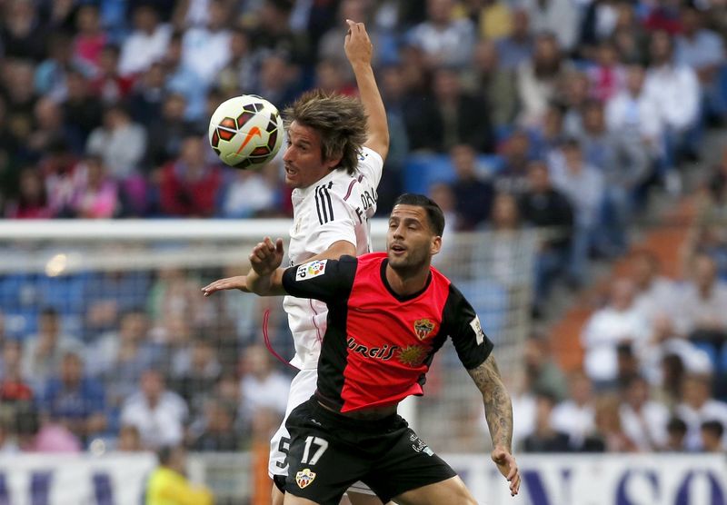 © Reuters. Real Madrid's Coentrao and Almeria's Mendez fight for the ball during their Spanish first division soccer match in Madrid