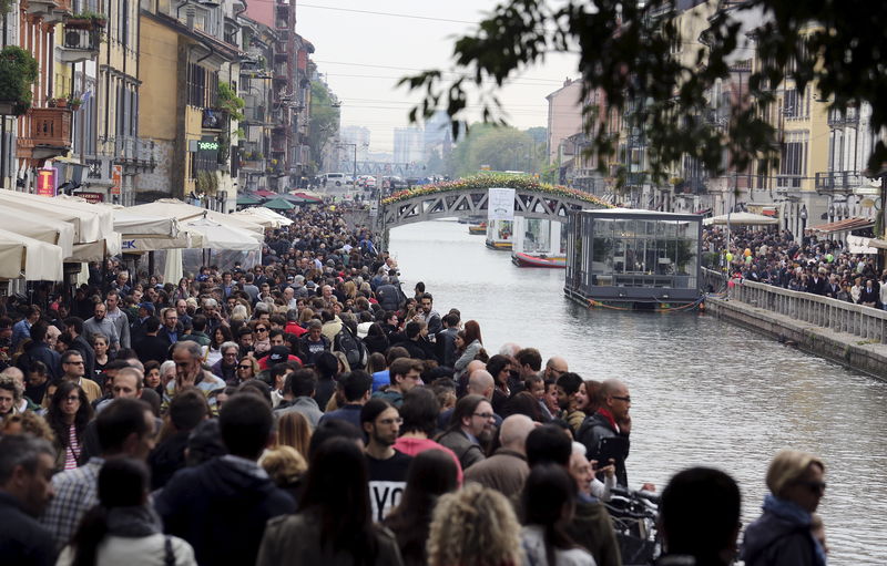 © Reuters. People stroll alongside the Navigli District, a network of interconnected canals in Milan