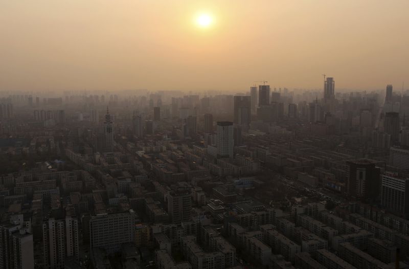 © Reuters. A general view shows the sun setting above residential and business buildings in Shenyang