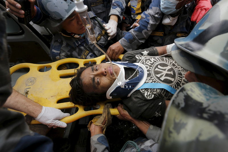 © Reuters. Pema Lama, de 15 anos, sendo levado para ambulância após resgate em Katmandu