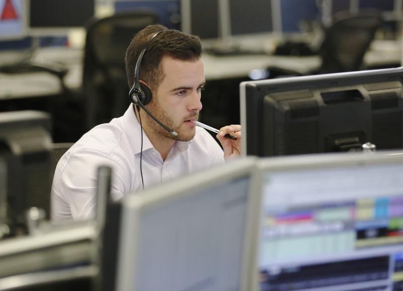 © Reuters. A trader sits at his desk at IG Index in London