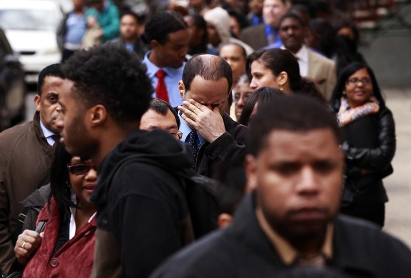© Reuters. Man rubs his eyes as he waits in a line of jobseekers, to attend the Dr. Martin Luther King Jr. career fair held by the New York State department of Labor in New York