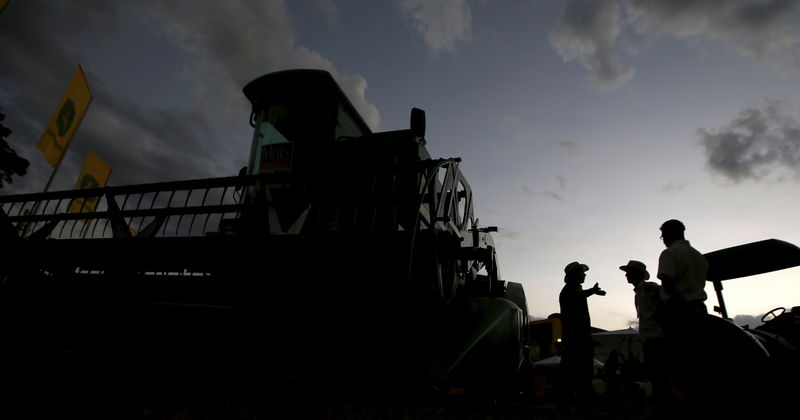 © Reuters. Agricultores conversam ao lado de colheitadeira na Agrishow