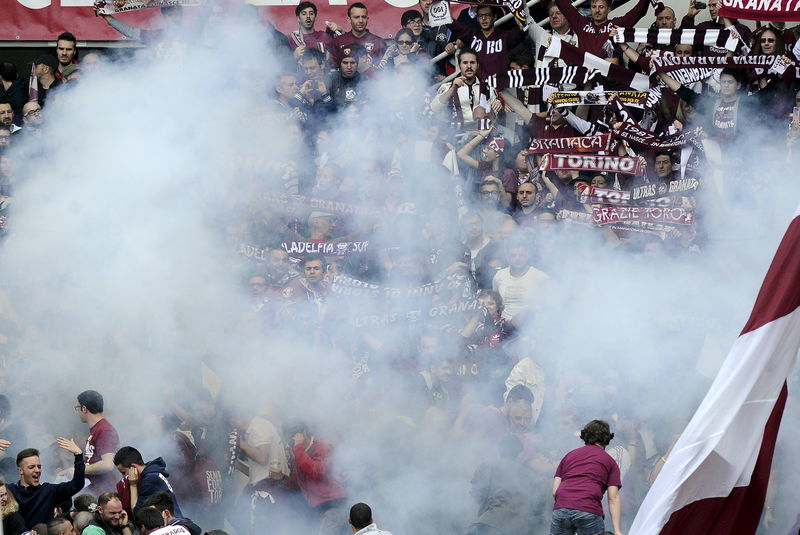 © Reuters. Torino's supporters look on as a firework explode during their Italian Serie A soccer match against Juventus in Turin