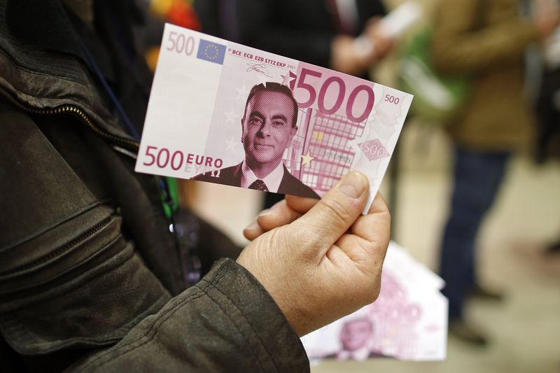 © Reuters. A labour council representative holds a facsimile 500 euros note with the portrait of Carlos Ghosn, Chairman and CEO of the Renault-Nissan Alliance, before the French carmaker Renault's shareholders general meeting in Paris