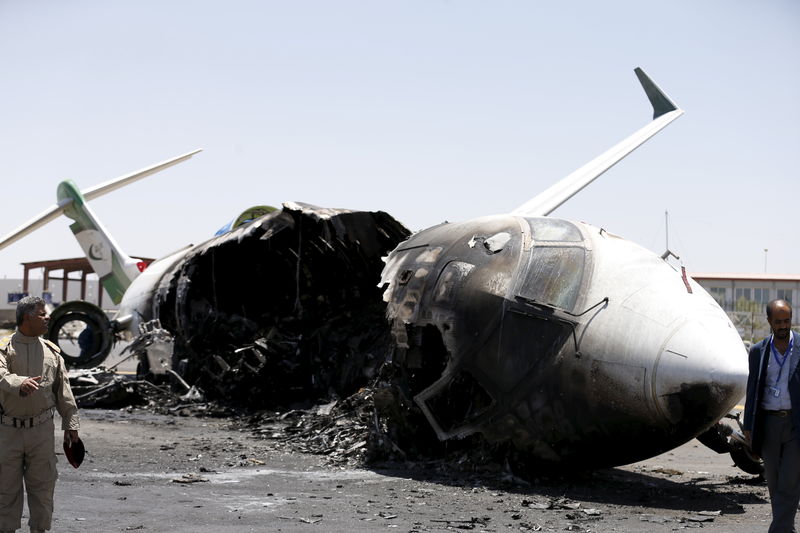 © Reuters. Autoridades aeroportuárias observam a aeronave destruída da Felix Airways