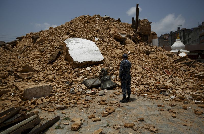© Reuters. Membro da polícia do Nepal olha para escombros do terremoto na capital Katmandu.