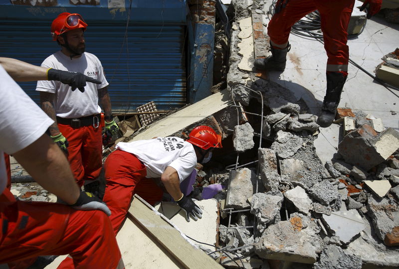 © Reuters. Equipes de resgate buscam sobreviventes de terremoto no Nepal, durante operação conjunta de equipes da Suíça e França.