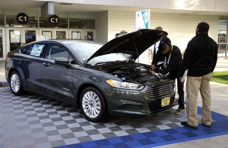 © Reuters. Workers prepare a 2015 Ford Fusion hybrid car for display at the International Consumer Electronics show in Las Vegas