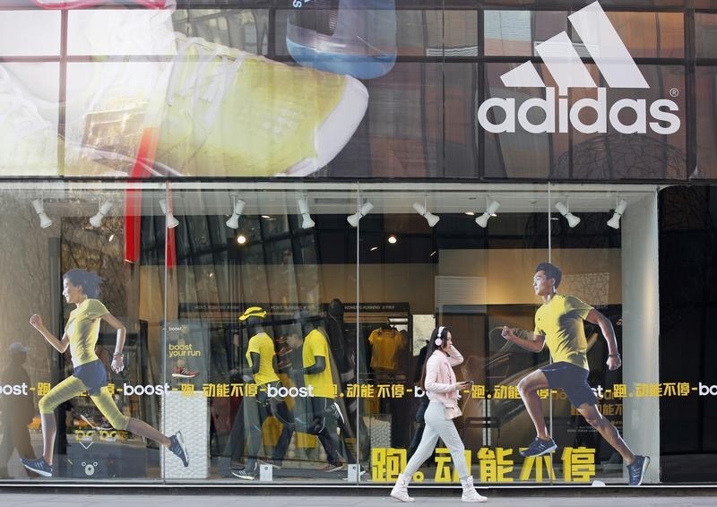 © Reuters. A woman walks past an Adidas shop at a shopping district in Beijing