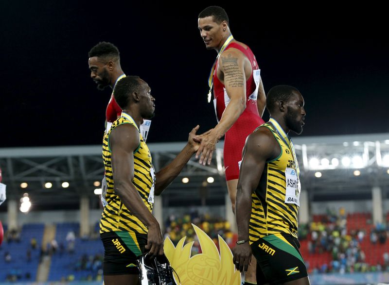 © Reuters. Bailey of the U.S. shakes hands with Jamaica's Bolt on the medals podium after the U.S. won the 4x100 meters race at the IAAF World Relays Championships in Nassau