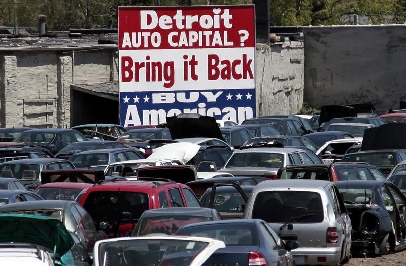 © Reuters. A large 'Buy American' sign, in support of Detroit's auto industry, is seen in the back of an auto scrap yard in Detroit, Michigan.