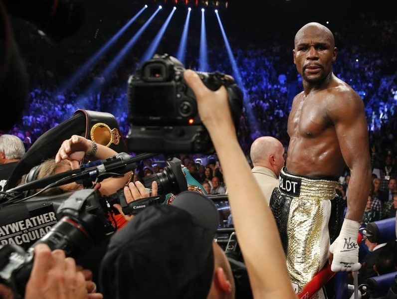 © Reuters. Mayweather, Jr. of the U.S. is surrounded by cameras after defeating Pacquiao of the Philippines in their welterweight title fight in Las Vegas