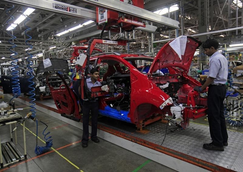 © Reuters. Employees work on a Chevrolet Beat car on an assembly line at the General Motors plant in Talegaon