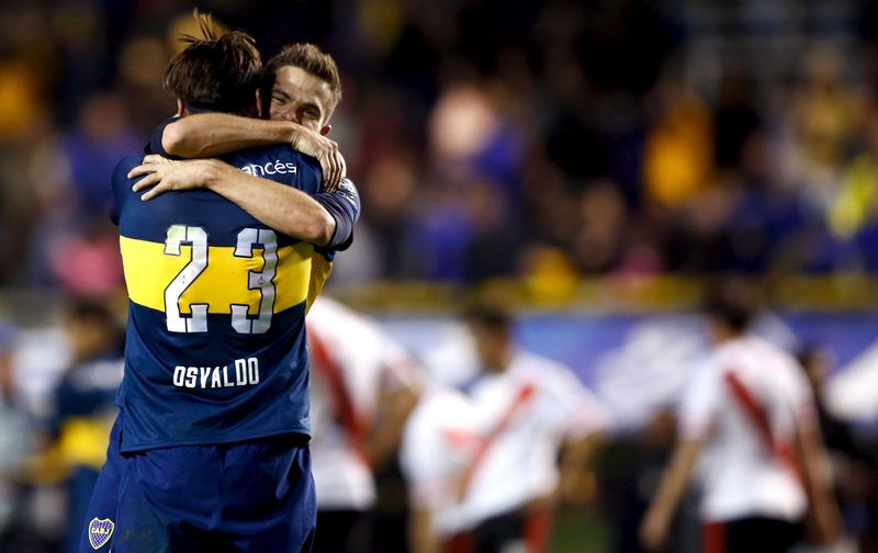 © Reuters. Boca Juniors' Osvaldo and Gago embrace as they celebrate after winning their Argentine First Division soccer match against River Plate in Buenos Aires