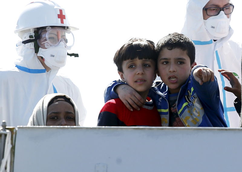 © Reuters. Boys chat as they arrive with migrants at the Sicilian harbor of Augusta