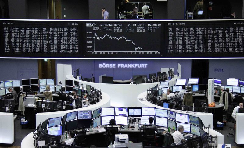 © Reuters. Traders are pictured at their desks in front of the DAX board at the Frankfurt stock exchange