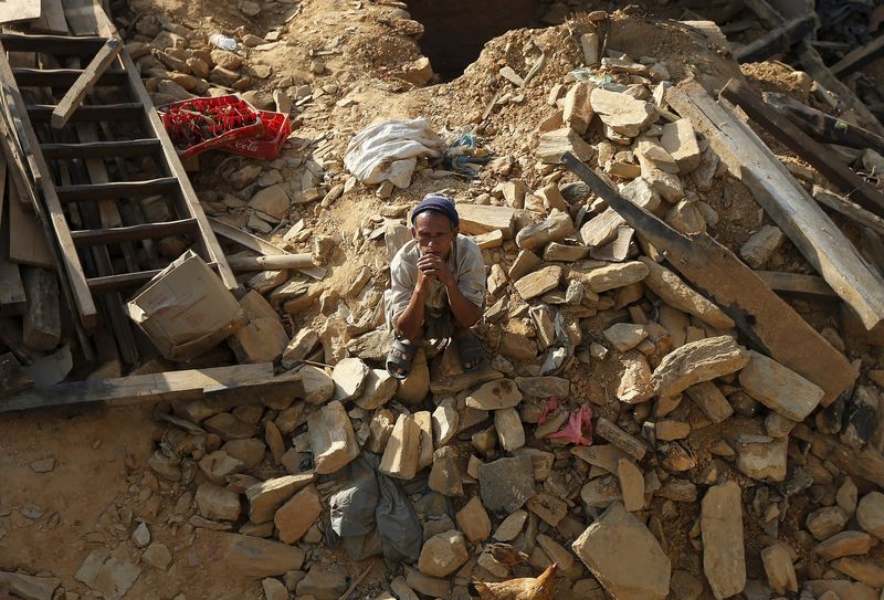 © Reuters. Vítima do terremoto sentado nos destroços de uma casa no vilarejo de Sindhupalchowk