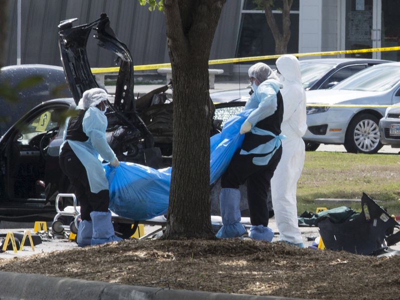 © Reuters. The bodies of two gunmen are removed from behind a car during an investigation by the FBI and local police in Garland