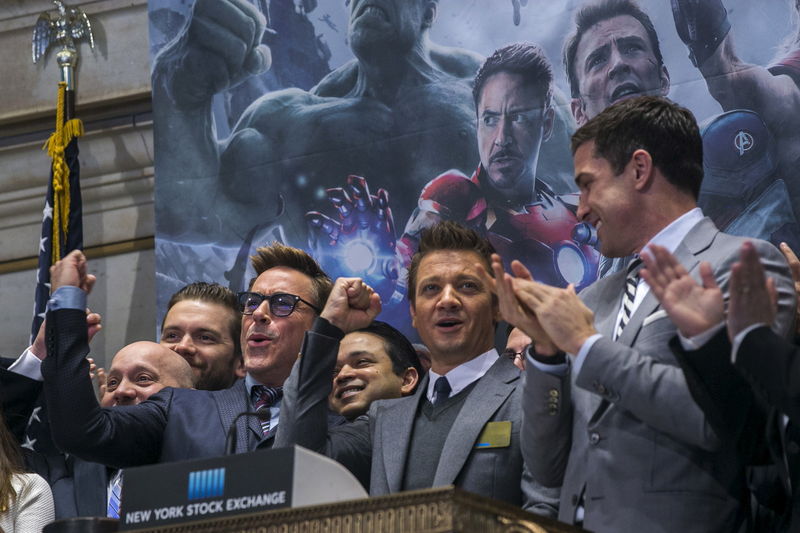 © Reuters. Actors Robert Downey Jr. (L) and Jeremy Renner (C) gesture as they ring the opening bell of the New York Stock Exchange to promote the film Avengers: Age of Ultron in New York