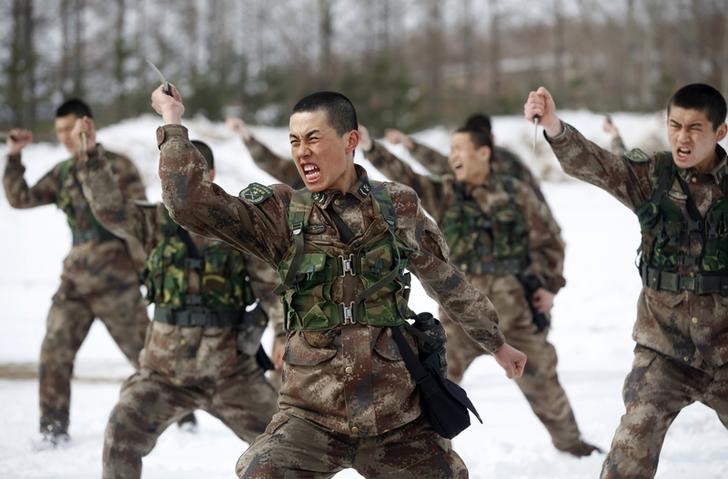 © Reuters. People's Liberation Army (PLA) soldiers shout as they practise with knives during a training session on snow-covered ground at a military base in Heihe