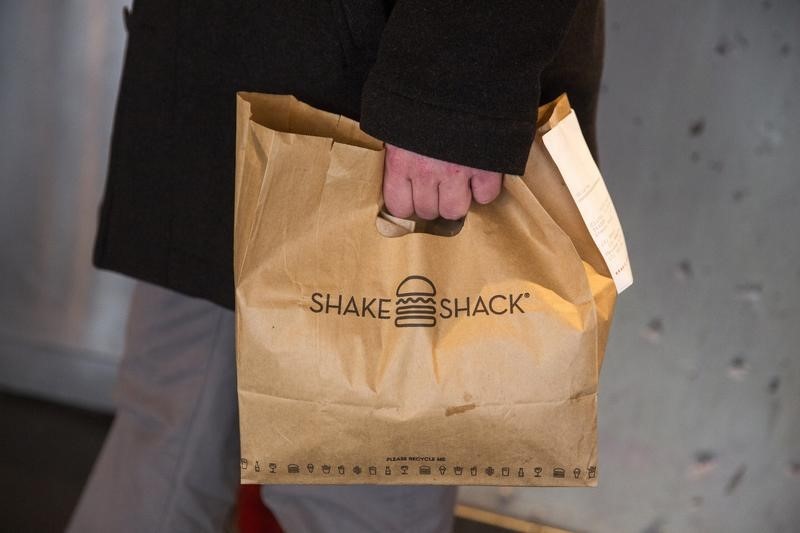 © Reuters. A customer holds a bag full of food inside of a Shake Shack store in New York