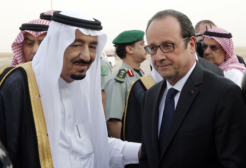 © Reuters. French President Hollande is greeted by Saudi Arabia's King Salman upon his arrival at Riyadh airport