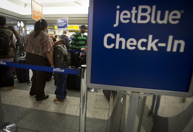 © Reuters. People wait in line at the JetBlue counter at La Guardia airport in New York