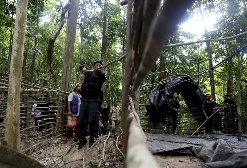 © Reuters. Security forces and rescue workers inspect an abandoned camp in a jungle in Thailand's southern Songkhla province