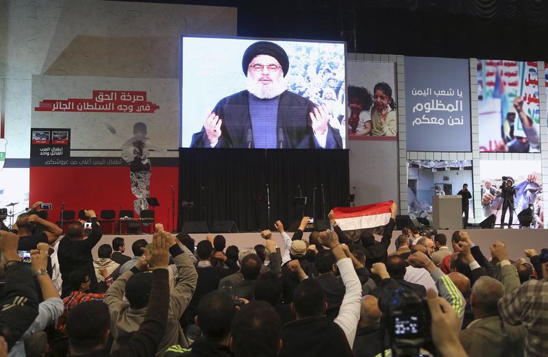 © Reuters. Lebanon's Hezbollah leader Nasrallah greets his Lebanese and Yemeni supporters through a giant screen during a speech against US-Saudi aggression in Yemen, in Beirut's southern suburbs