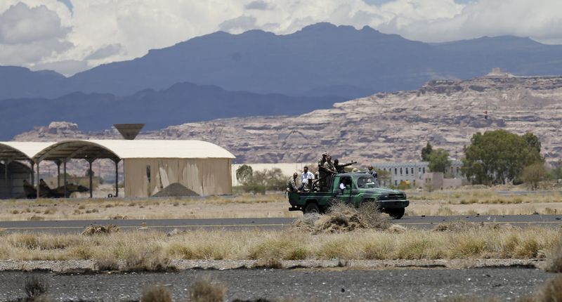 © Reuters. Militantes houthis no aeroporto internacional de Sanaa