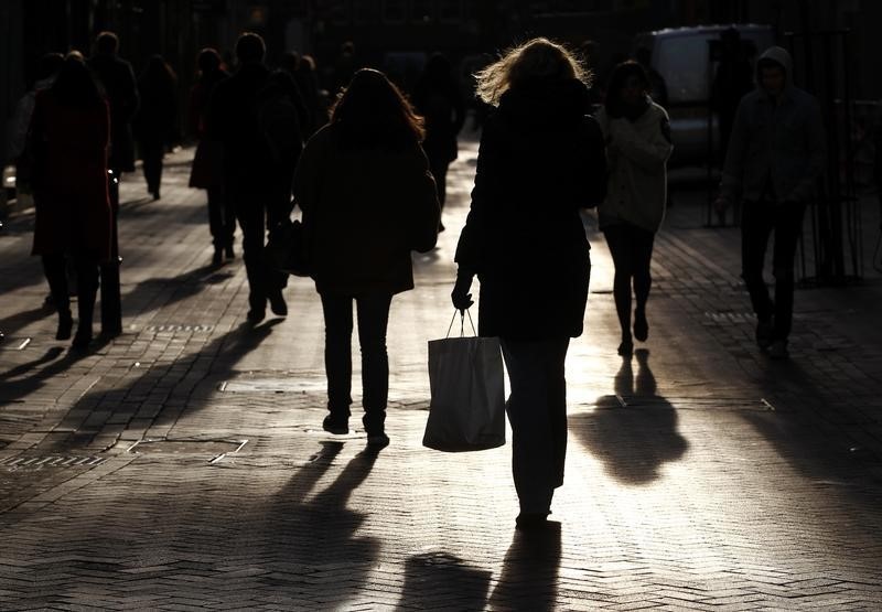 © Reuters. A woman carries a shopping bag as she walks in central London