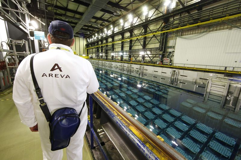 © Reuters. A technician walks along the pool storage where spent nuclear fuel tanks are unload in baskets under 4 meters of water to decrease temperature as part of the treatment of nuclear waste at the Areva Nuclear Plant of La Hague, near Cherbourg