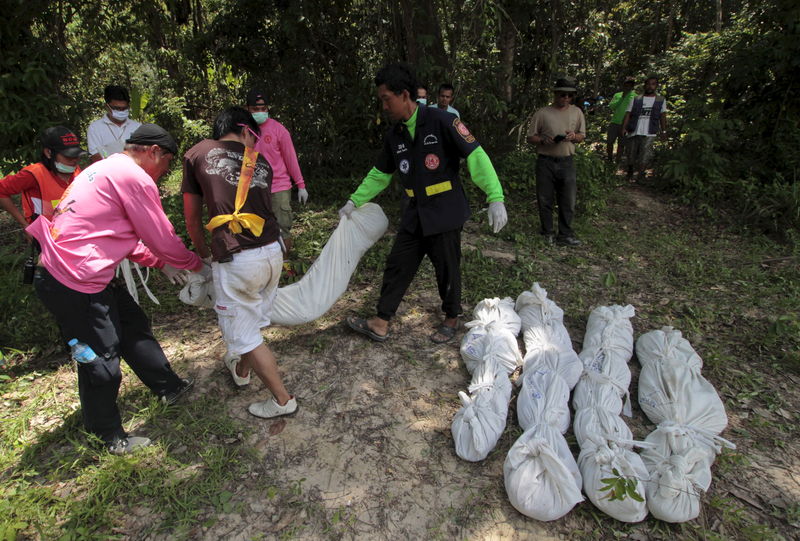 © Reuters. Trabalhadores retirando restos de corpos encontrados na província de Songkhla, no sul da Tailândia