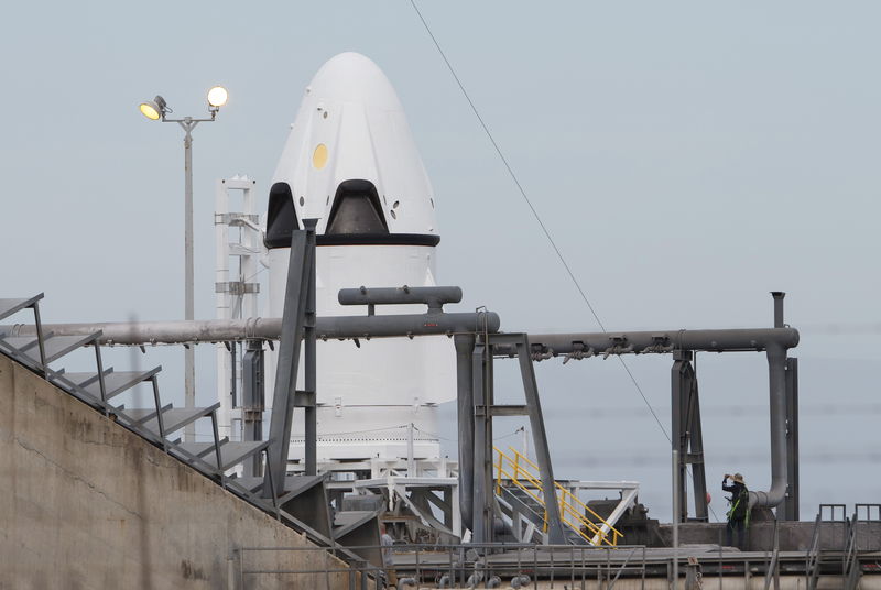 © Reuters. A SpaceX worker stands near the unmanned SpaceX Crew Dragon as it sits on launch pad 40 before a Pad Abort Test at the Cape Canaveral Air Force Station in Cape Canaveral, Florida