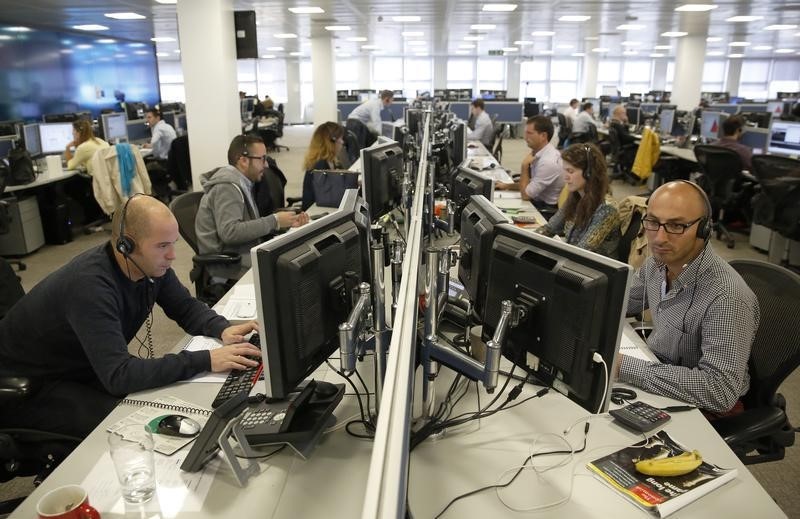 © Reuters. Traders sit at their desks at IG Index in London