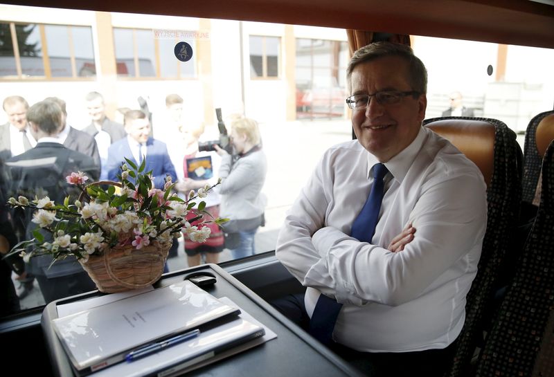 © Reuters. Poland's President Bronislaw Komorowski, presidential candidate of Civic Platform, smiles as he sits inside a bus during his election campaign at the Bankiewicz's apple orchard in Komorow